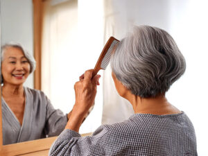 鏡の前でブラッシングするシニア女性