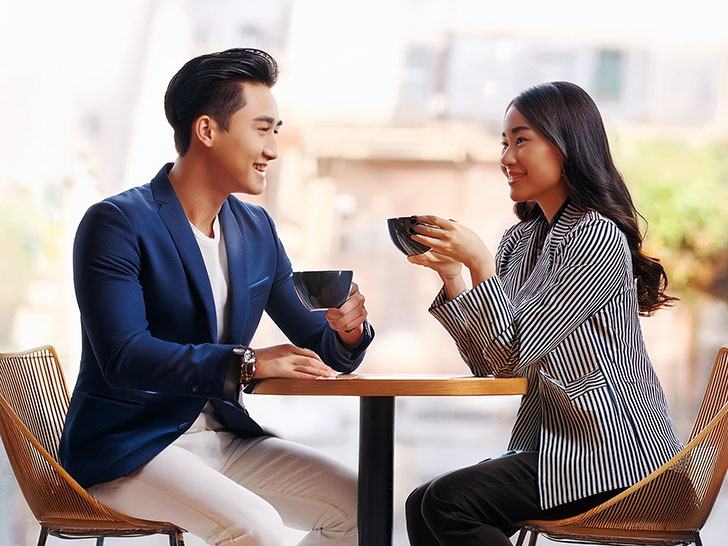 カフェでコーヒーを飲む若いカップル