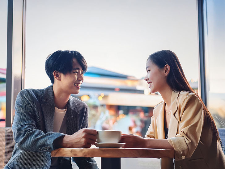 カフェでコーヒーを飲む若いカップル