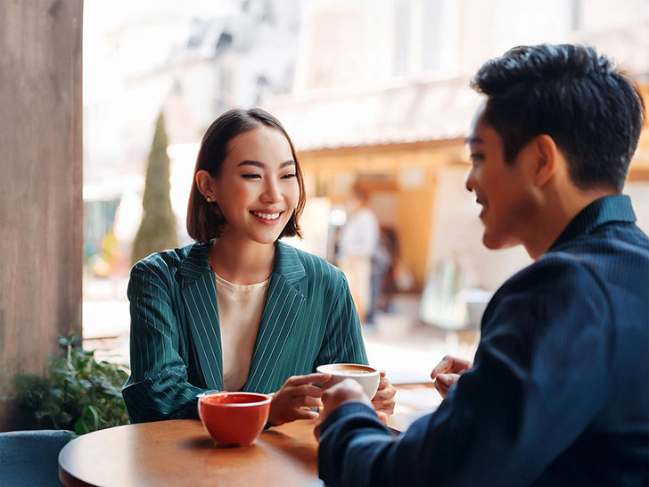 カフェでコーヒーを飲む若いカップル