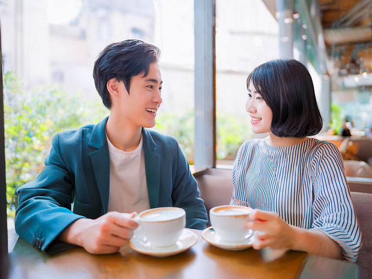 カフェでコーヒーを飲む若いカップル