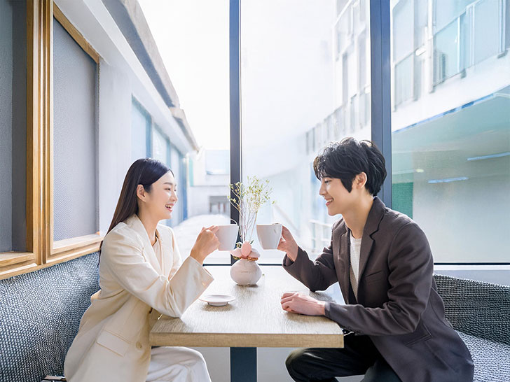 カフェでコーヒーを飲む若いカップル