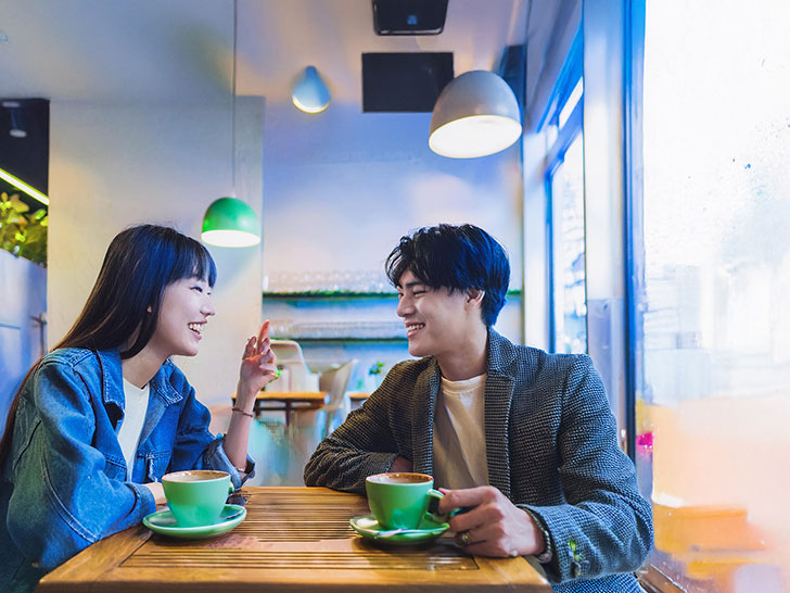 カフェでコーヒーを飲む若いカップル