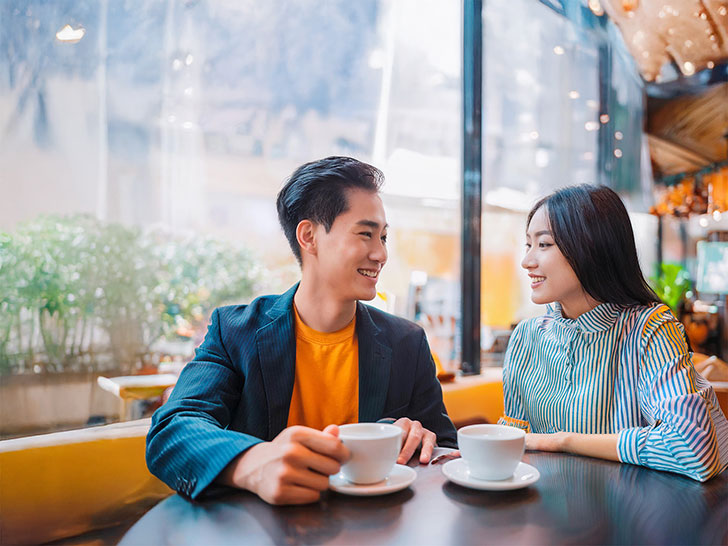 カフェでコーヒーを飲む若いカップル