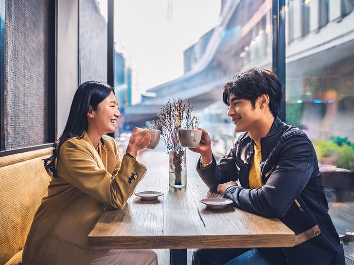 カフェでコーヒーを飲む若いカップル