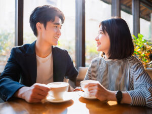 カフェでコーヒーを飲む若いカップル