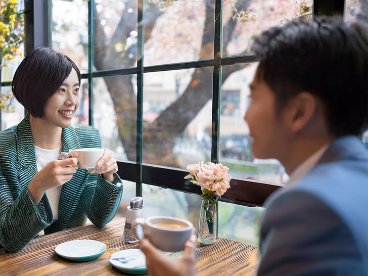 カフェでコーヒーを飲む若いカップル