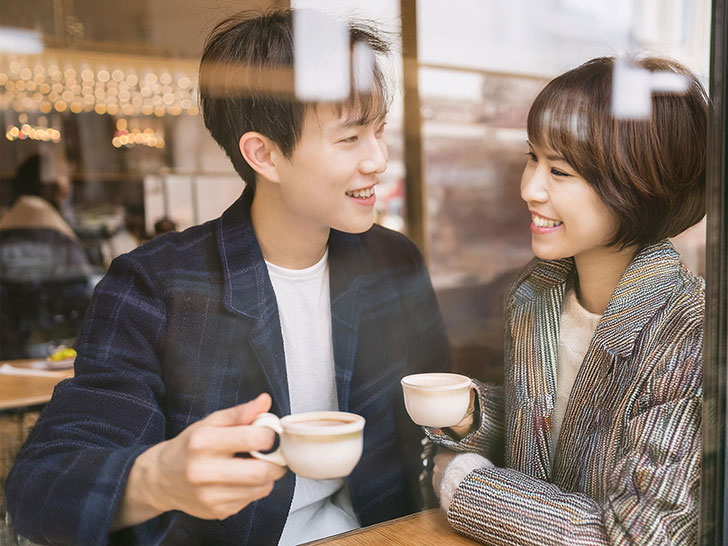 カフェでコーヒーを飲む若いカップル