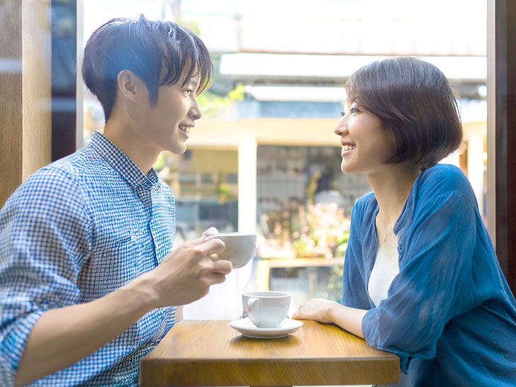 カフェでコーヒーを飲む若いカップル