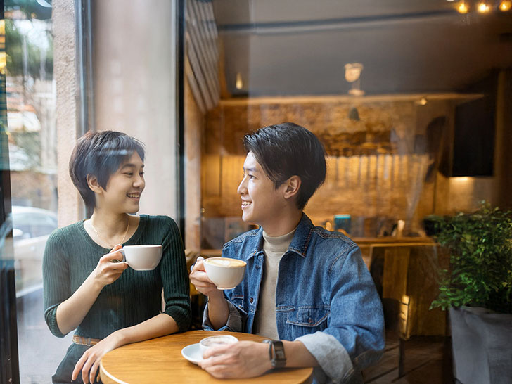 カフェでコーヒーを飲む若いカップル