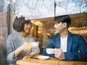 カフェでコーヒーを飲む若いカップル