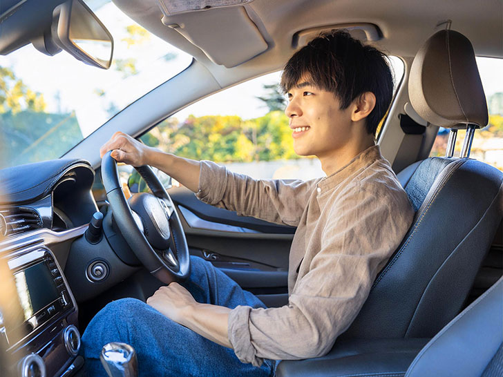 車を運転する若い男性