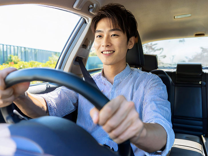 車を運転する若い男性