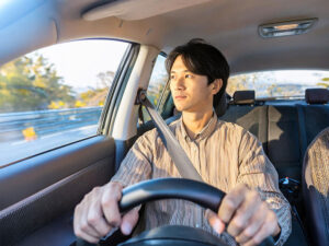 車を運転する若い男性