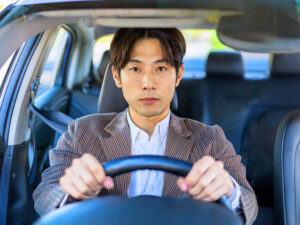 車を運転する若い男性