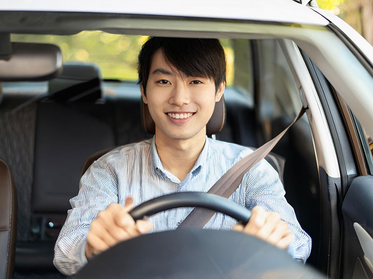 車を運転する若い男性