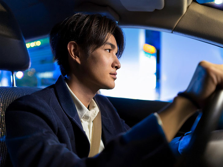 車を運転する若い男性