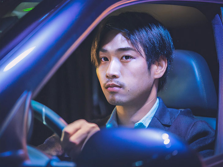 車を運転する若い男性