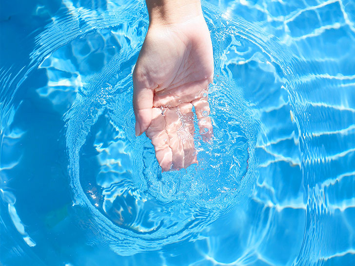 透明な水をすくう女性の手