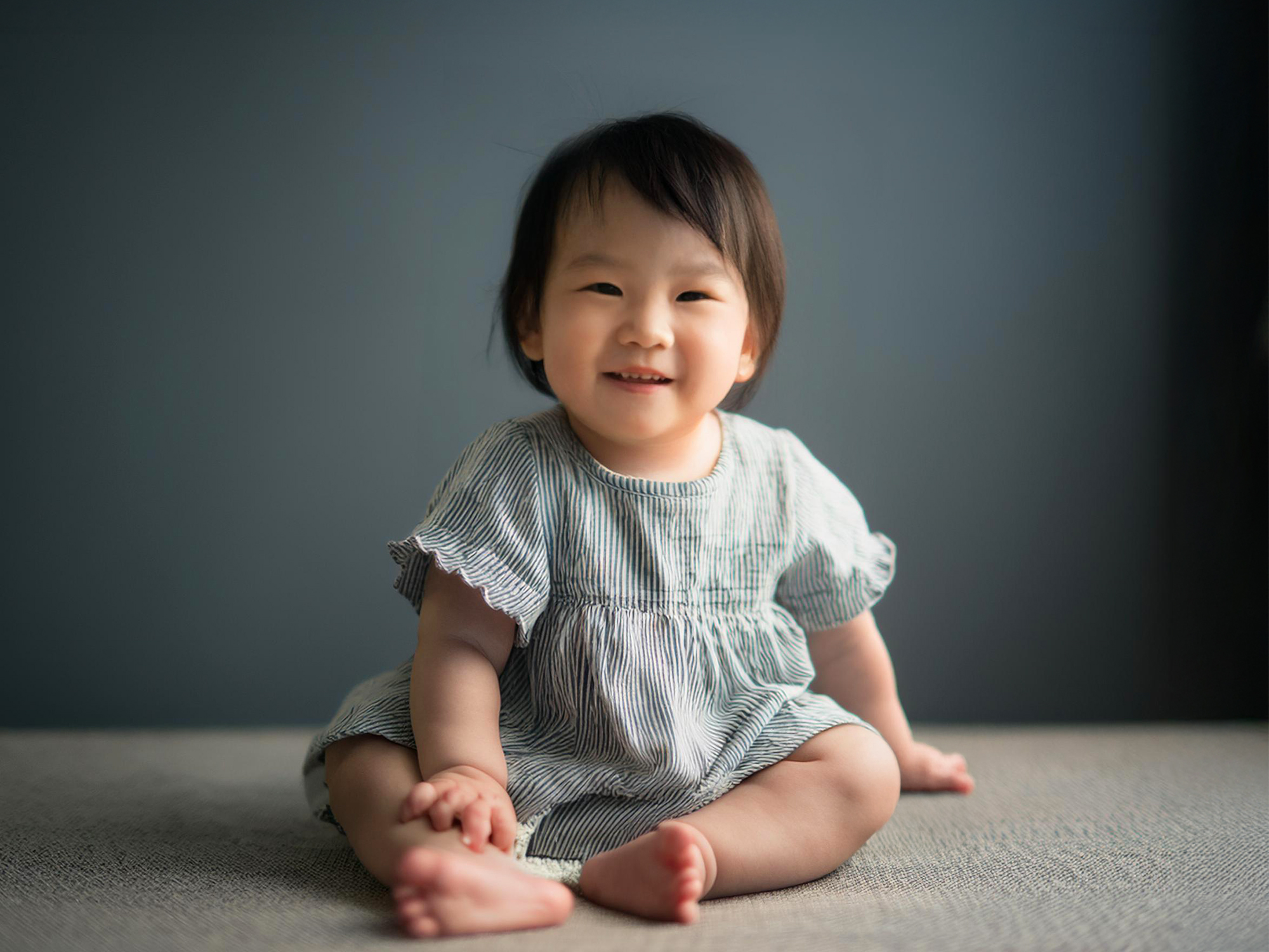 座ってとびきりの笑顔を見せる赤ちゃん
