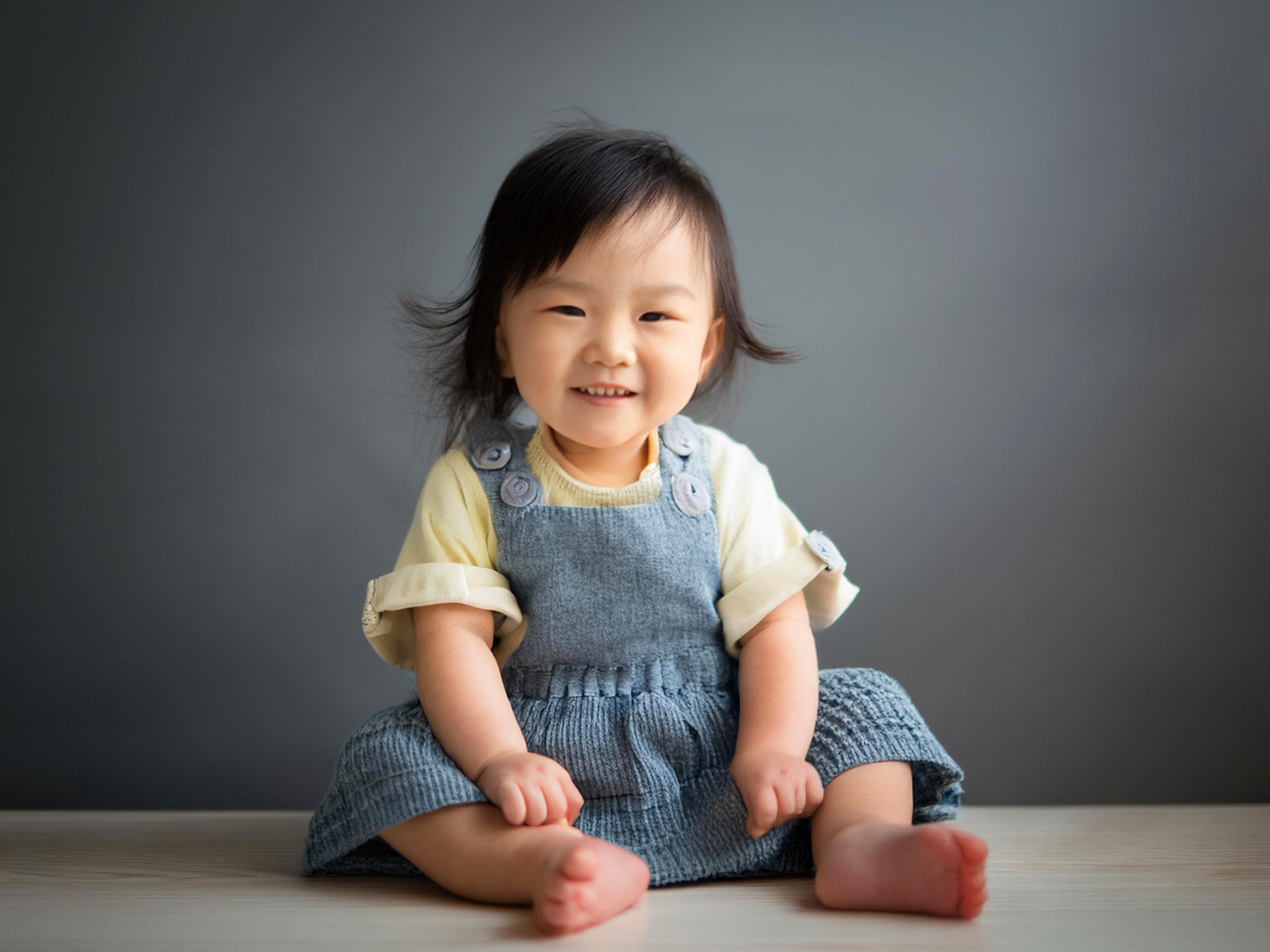 座ってとびきりの笑顔を見せる赤ちゃん