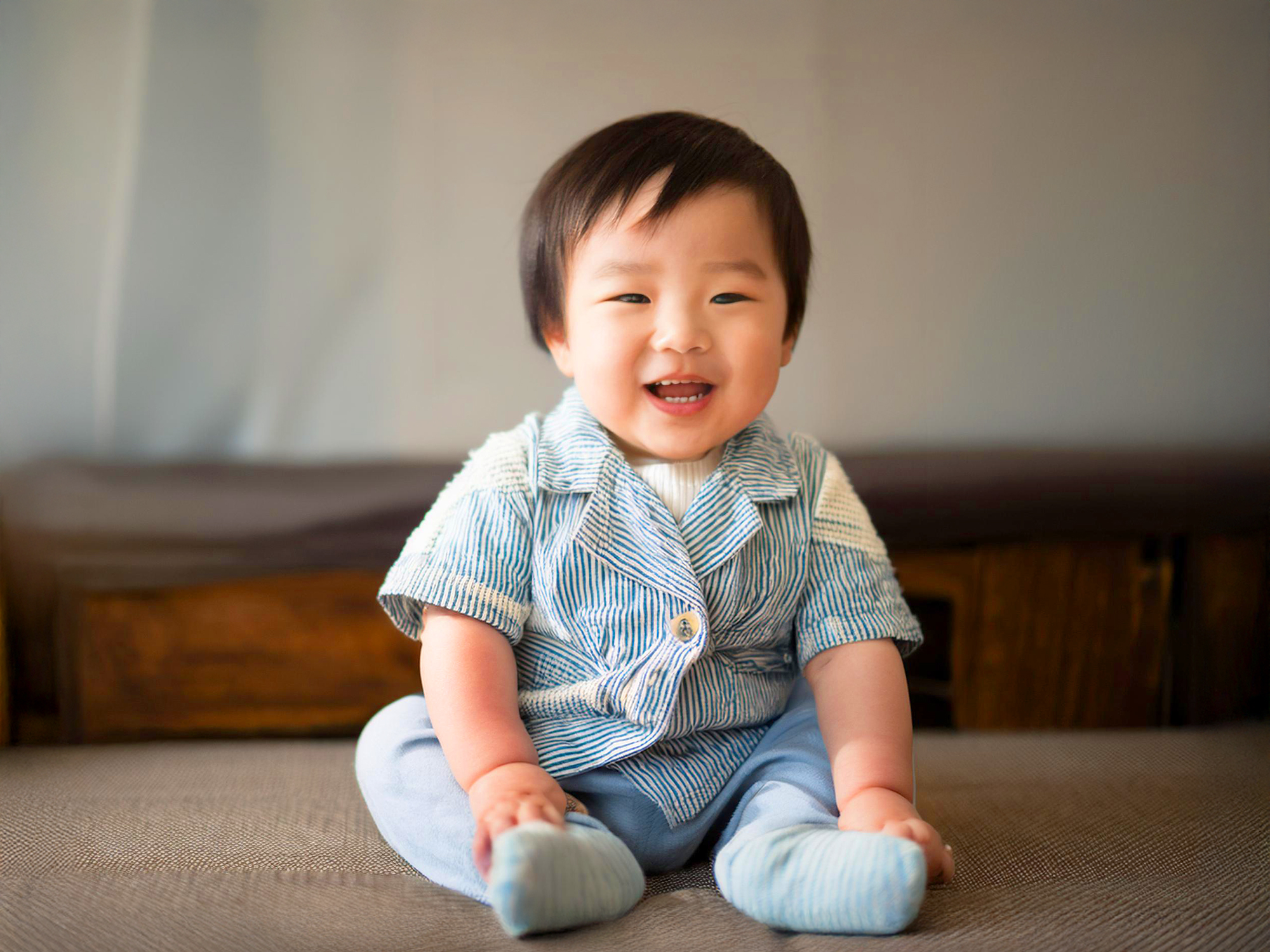 座ってとびきりの笑顔を見せる赤ちゃん