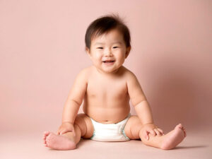 座ってとびきりの笑顔を見せる赤ちゃん