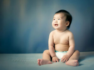 座ってとびきりの笑顔を見せる赤ちゃん