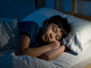 ベッドで眠る小さな男の子
