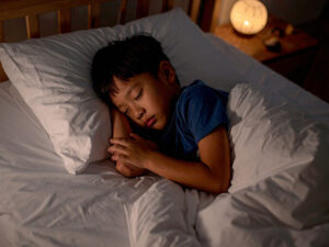ベッドで眠る小さな男の子