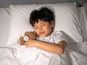 ベッドで眠る小さな男の子
