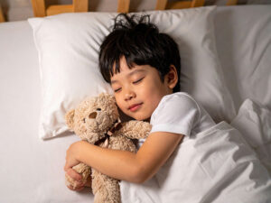 ベッドで眠る小さな男の子