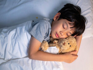 ベッドで眠る小さな男の子