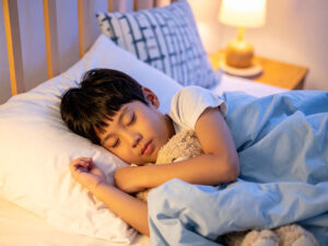 ベッドで眠る小さな男の子