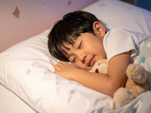 ベッドで眠る小さな男の子