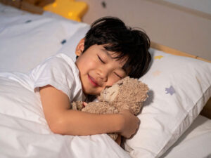 ベッドで眠る小さな男の子