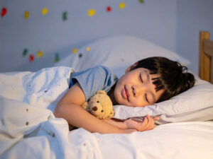 ベッドで眠る小さな男の子