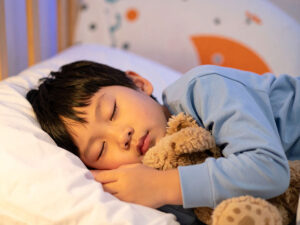 ベッドで眠る小さな男の子