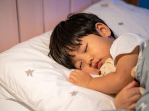 ベッドで眠る小さな男の子