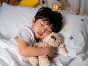 ベッドで眠る小さな男の子