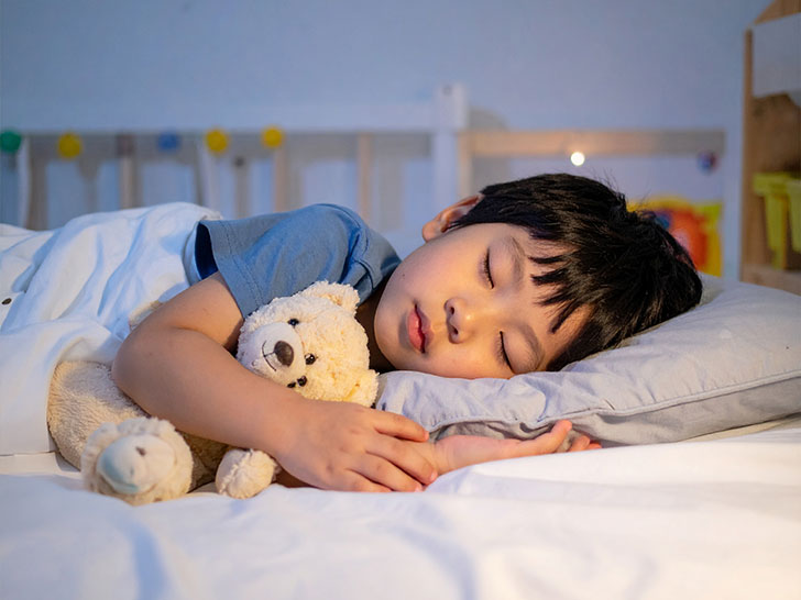 ベッドで眠る小さな男の子