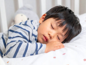 ベッドで眠る小さな男の子