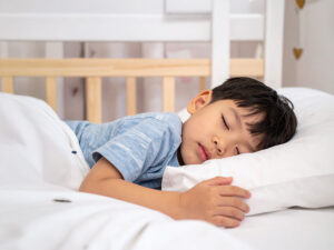 ベッドで眠る小さな男の子