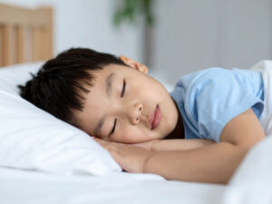 ベッドで眠る小さな男の子