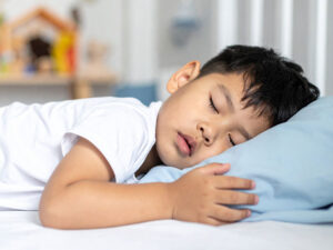 ベッドで眠る小さな男の子