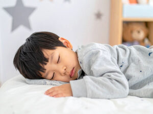 ベッドで眠る小さな男の子