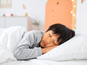 ベッドで眠る小さな男の子