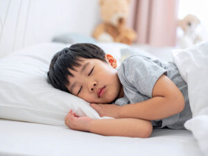 ベッドで眠る小さな男の子