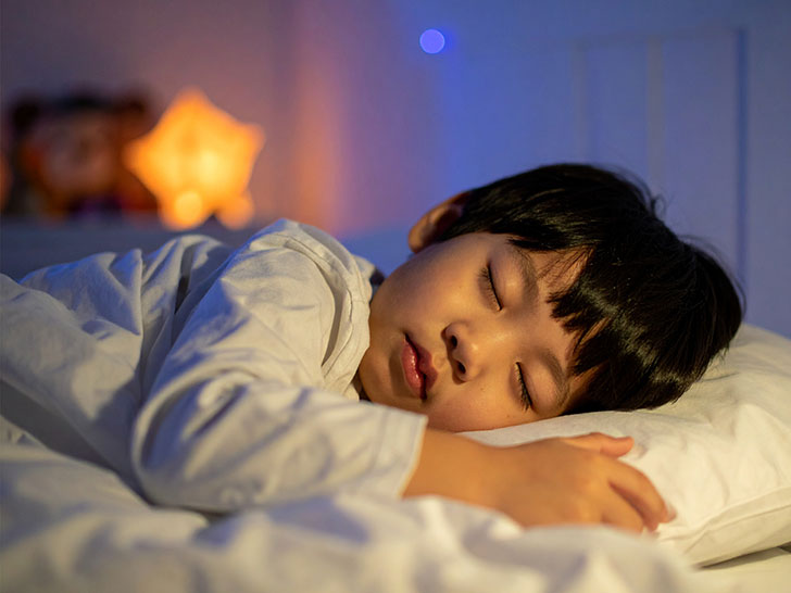 ベッドで眠る小さな男の子