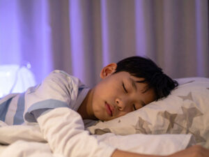 ベッドで眠る小さな男の子